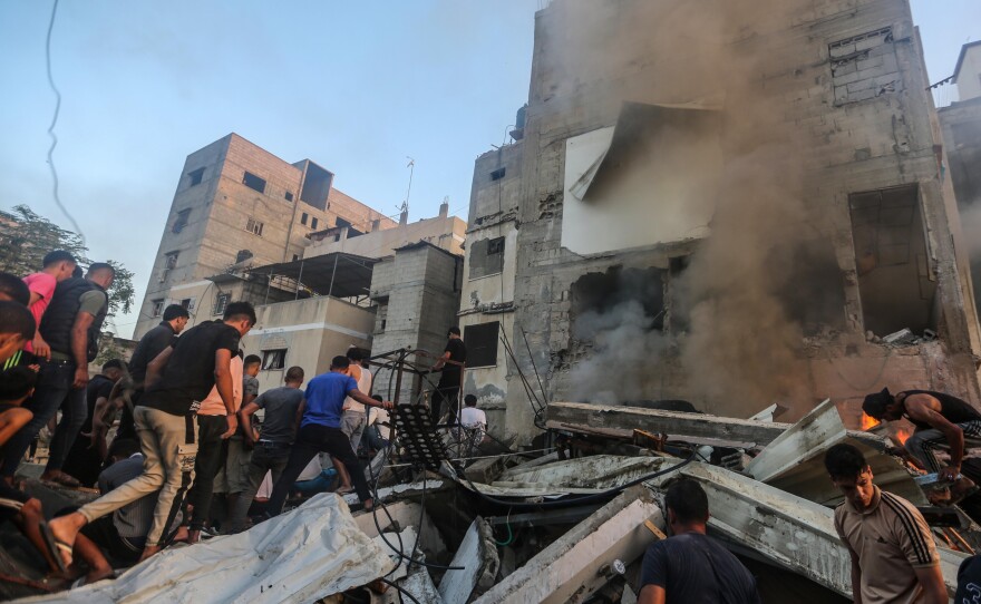 People search through buildings that were destroyed during Israeli air raids in the southern Gaza Strip on Saturday in Khan Younis, Gaza.