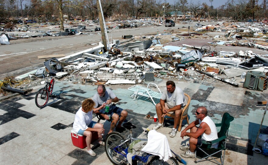 (From left) Judee English, 'Wild Bill' Laprime, Brian Mollere and Orville Ferrell sit on what remained of Mollere's business on the main street in Waveland, Miss., in September 2005. The entire town of Waveland was completely destroyed by Hurricane Katrina 10 years ago.