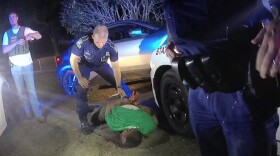 FILE — This image from video from Louisiana state trooper Lt. John Clary's body-worn camera shows trooper Kory York standing over Ronald Greene on his stomach on May 10, 2019, outside of Monroe, La.