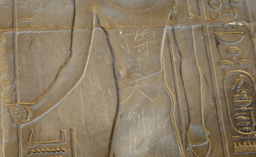 Chinese characters that read "Ding Jinhao was here" are seen on the torso of figure on the wall of a 2,500-year-old temple in Luxor, Egypt, in 2013. A 15-year-old Chinese boy scratched the characters onto the wall of the ancient site.