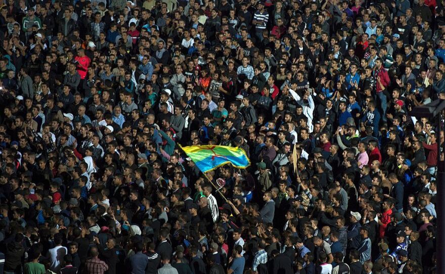 Protesters wave the Amazigh (Berber) flag as they shout slogans in the northern city of al-Hoceima on Sunday after the death of Mouhcine Fikri.