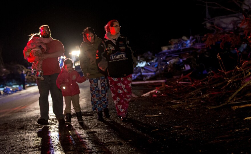 Stefanie and Matthew Hurley and their family look at wreckage after a tornado came through the town of Fairdale, Ill., earlier in the day Thursday.