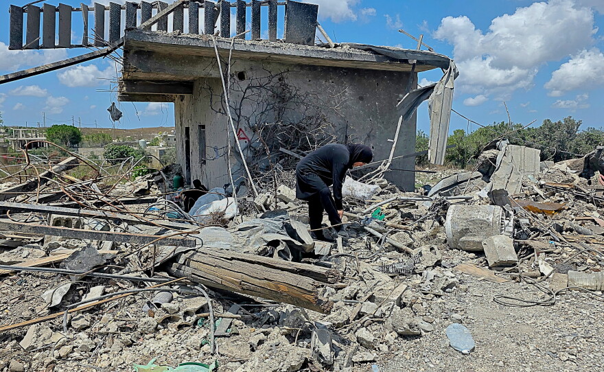 A Lebanese woman clears debris of her destroyed house in the village of Zawtar al-Gharbiyeh, southern Lebanon, Sunday, July 26, 2026.