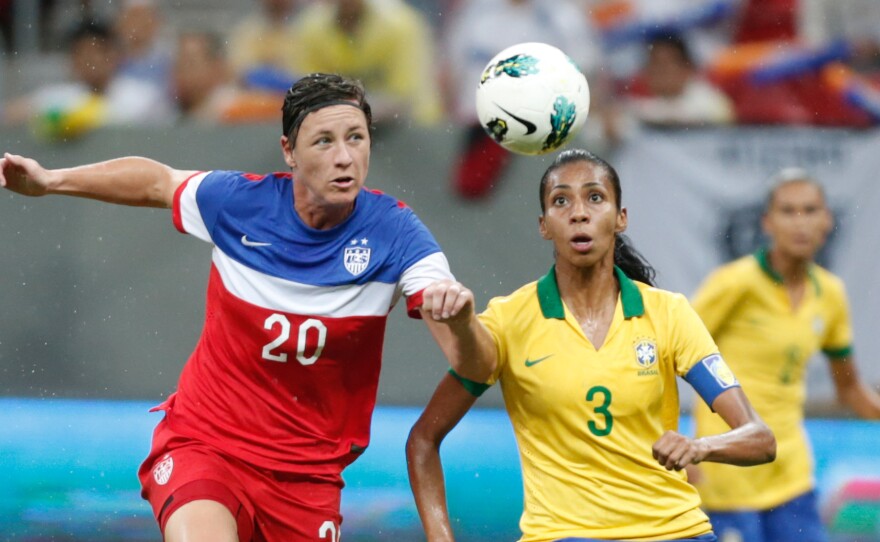 United States' Abby Wambach fights for the ball with Brazil's Bruna Benites during a final match of the International Women's Football Tournament in Brasilia, Brazil, Sunday. The game ended in a draw, giving Brazil the tournament victory.