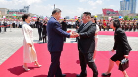 In this photo provided by the North Korean government, Chinese President Xi Jinping (center left) shakes hands with North Korean leader Kim Jong Un (center right) during a welcome ceremony in Pyongyang on Monday.
