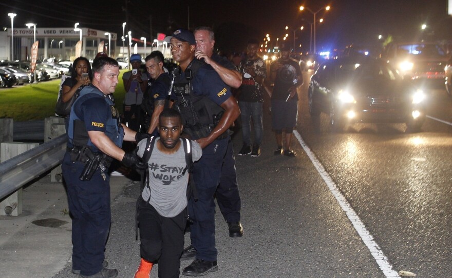 Police arrest activist DeRay Mckesson on Saturday, during a protest along Airline Highway, a major road that passes in front of the Baton Rouge Police Department headquarters in Baton Rouge, La.