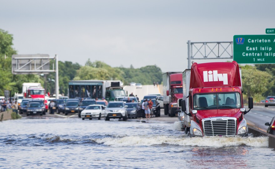 A trailer truck drives through a flooded Sunrise Highway in Islip.