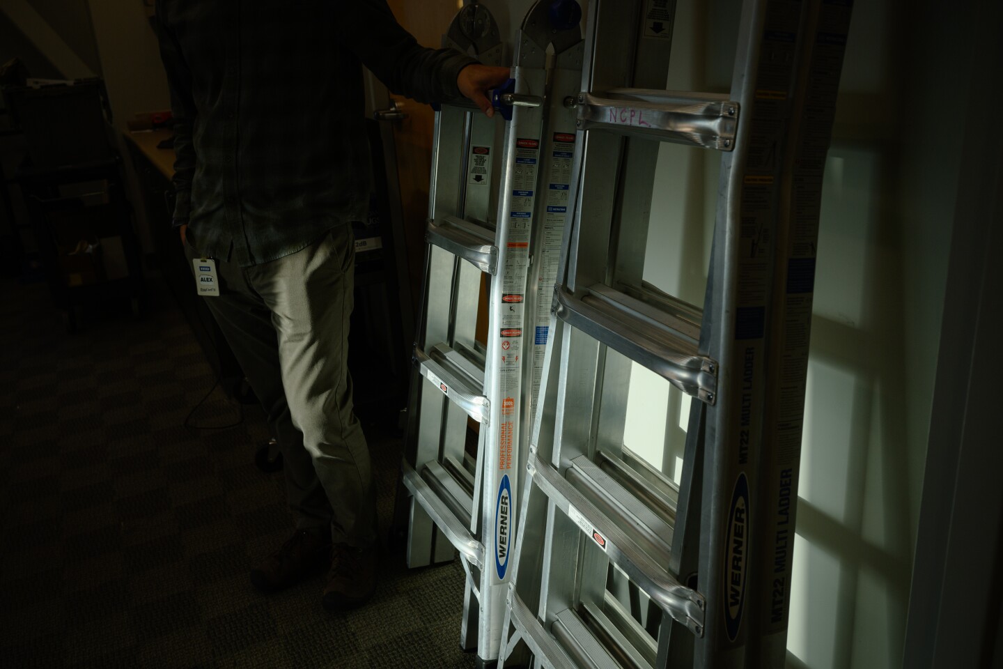 Alex Neu, an eResources and systems librarian with the National City Public Library in National City, California, stands with a set of ladders available through u-Tool-ize, the library's new tool lending program, on October 13, 2025.