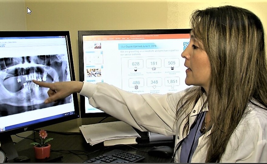 The clinic's dental director, Dr. Karen Becerra, points to a patient's X-ray, Feb. 15, 2017.