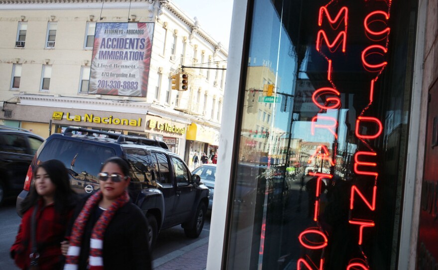 Hispanic residents walk by a law office in Union City, N.J., specializing in immigration in March. Union City is one of the state's largest cities, and has a Hispanic population of more than 80 percent.