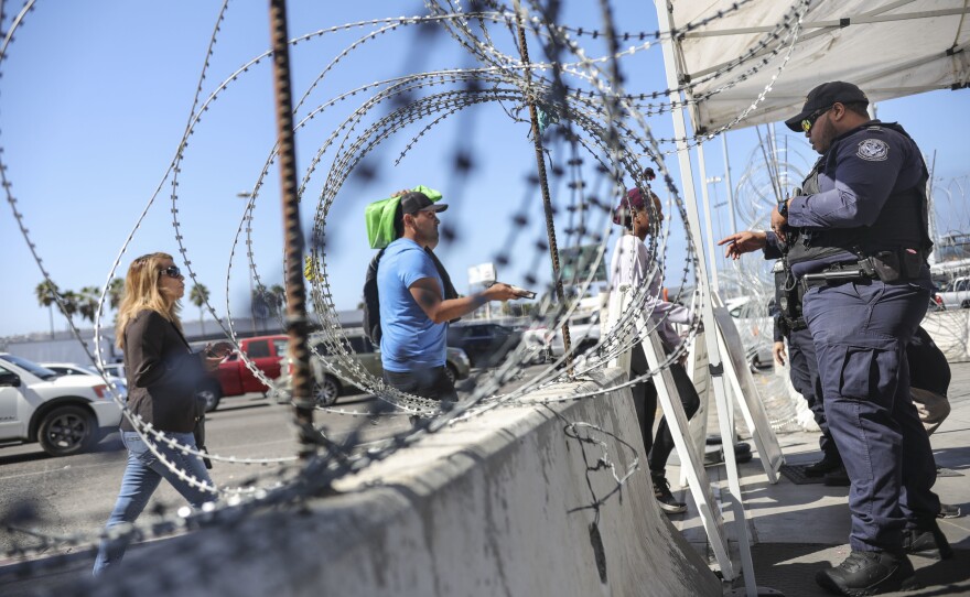An Immigration and Customs Enforcement agent checks pedestrians' documentation at the San Ysidro Port of Entry in San Ysidro, Calif., on Oct. 2.