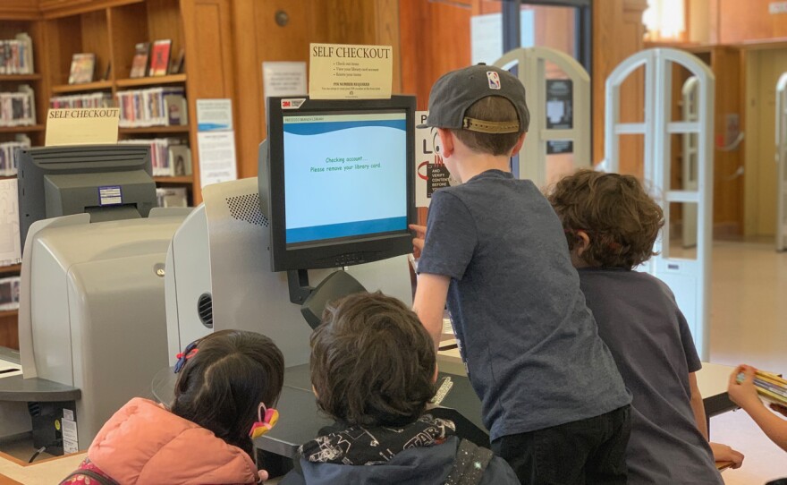 Kids at the self check-out at the Presidio Branch of the San Francisco Public Library.