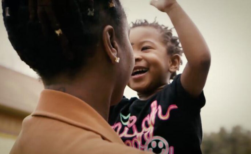 Promotional still of a woman holding her baby from the film "City Rising."