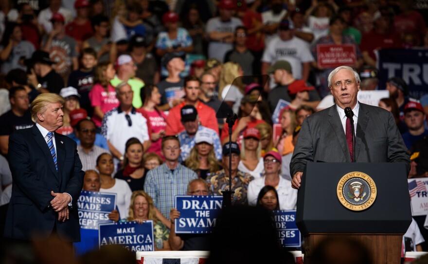 West Virginia Gov. Jim Justice announces that he is switching parties to become a Republican as President Trump listens on at a campaign rally Thursday in Huntington, W.Va.