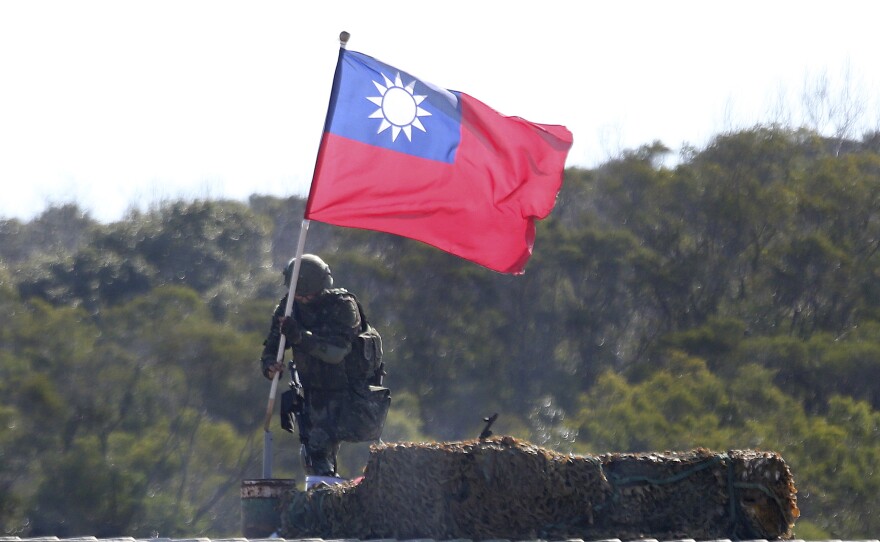 A soldier holds a Taiwanese flag during a military exercise in Hsinchu County, northern Taiwan, in January. Taiwanese troops using tanks, mortars and small arms staged a drill aimed at repelling an attack from China.