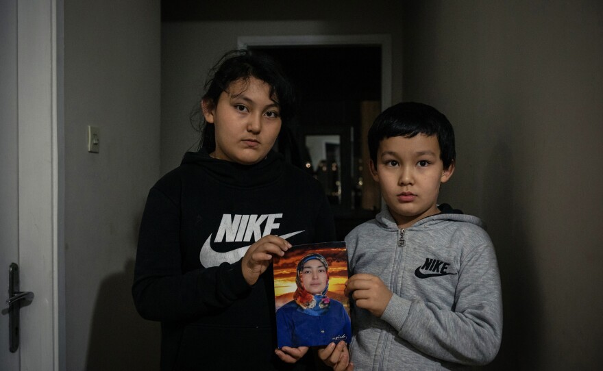 Aysu and Lütfullah hold a picture of their mother, Meryem Aimati, at their home in Istanbul. The children have not seen their mother for over two years, since they were released from state boarding schools and brought back to Turkey with their father.