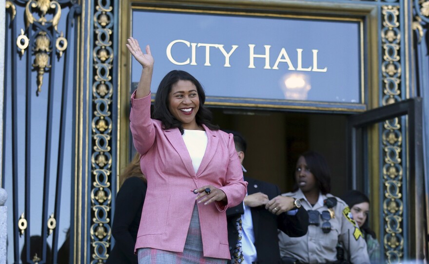 Mayor-elect London Breed waves before speaking to reporters on Wednesday outside City Hall in San Francisco.