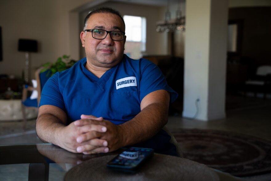 Dr. Hamid Zadeh, OBGYN, sits in his home in El Centro while juggling calls from the maternity ward at Pioneers Memorial Hospital on Aug. 23, 2024. 