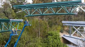 Construction crews place the last section of a new bridge at the San Diego Zoo, March 23, 2017.