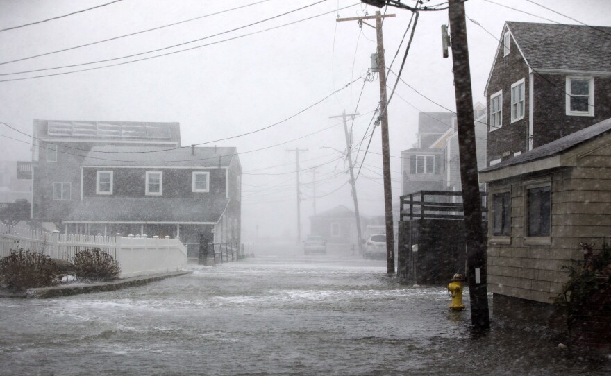 A road begins to flood in Scituate, Mass., during a massive winter storm on Thursday.