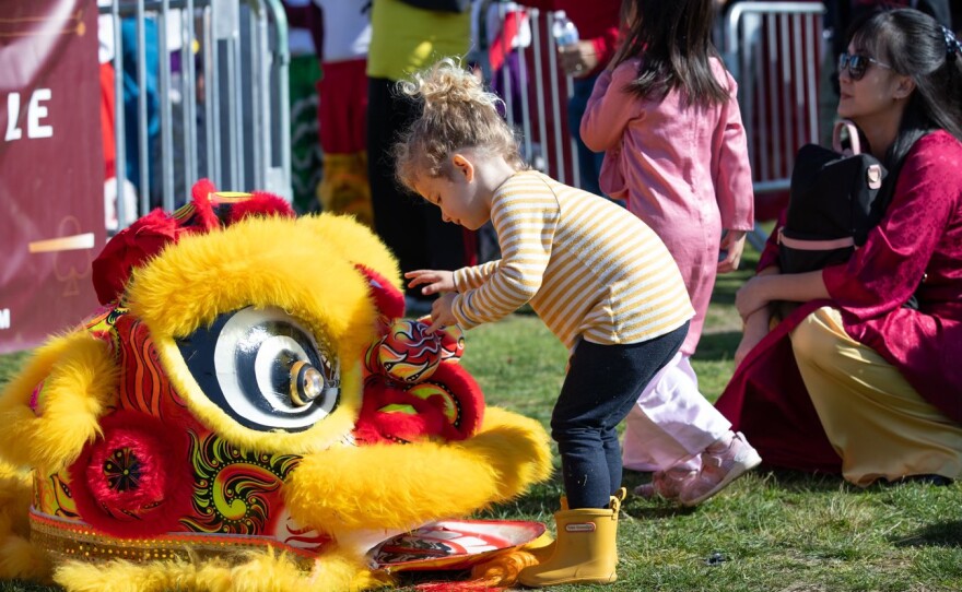 A young child checks out a lion dancing costume at the San Diego Tết Festival on Jan. 31, 2025.