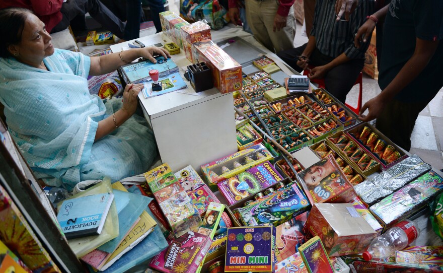 An Indian shopkeeper sits at her firecracker shop in New Delhi on Oct. 9, as India's top court ordered a temporary ban on the sale of firecrackers in New Delhi ahead of the Diwali festival.