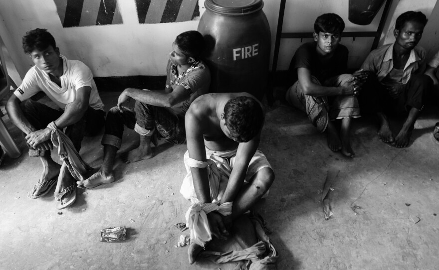 Workers suspected of vandalizing a car are detained by factory security personnel in Savar in May 2012.