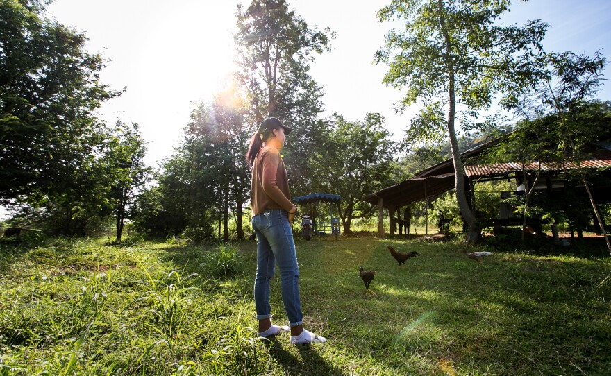 A poses for a photo at her family farm in a northeastern province. Her first name consists of the single initial.