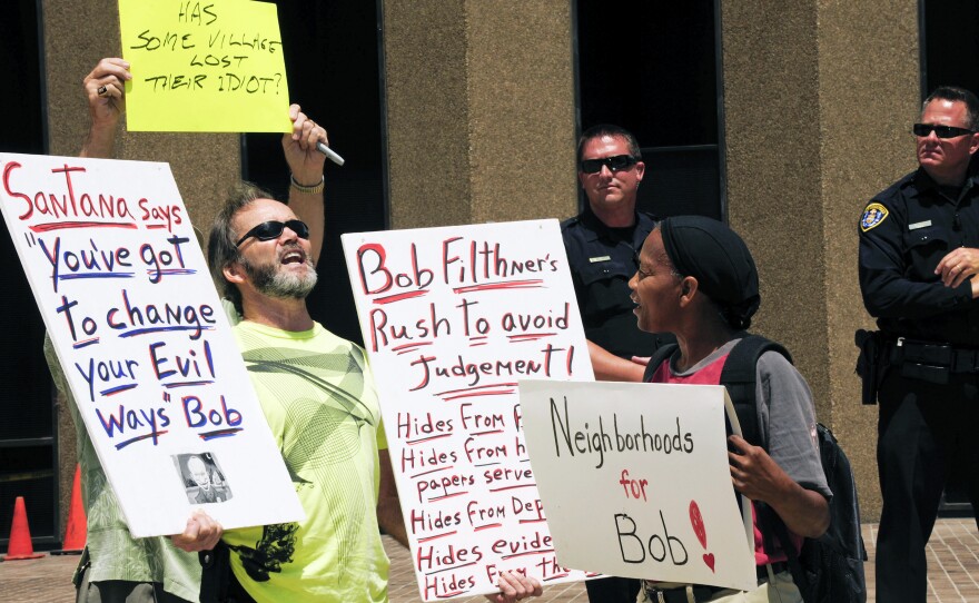 Ruth Johnson (right), who supports San Diego Mayor Bob Filner, speaks with anti-Filner protester Rob Shick (left) during a rally at the San Diego Concourse on Monday.