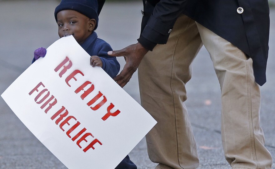 Lavon Massey, 1, holds a sign as part of a protest outside the U.S. Citizenship & Immigration Service office in New Orleans, Wednesday. Organizers were drawing attention to the possibility that many undocumented immigrants may not be shielded by the president's executive order.