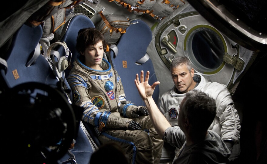 Alfonso Cuaron won best director for "Gravity." Here he is on the set with Sandra Bullock and George Clooney.