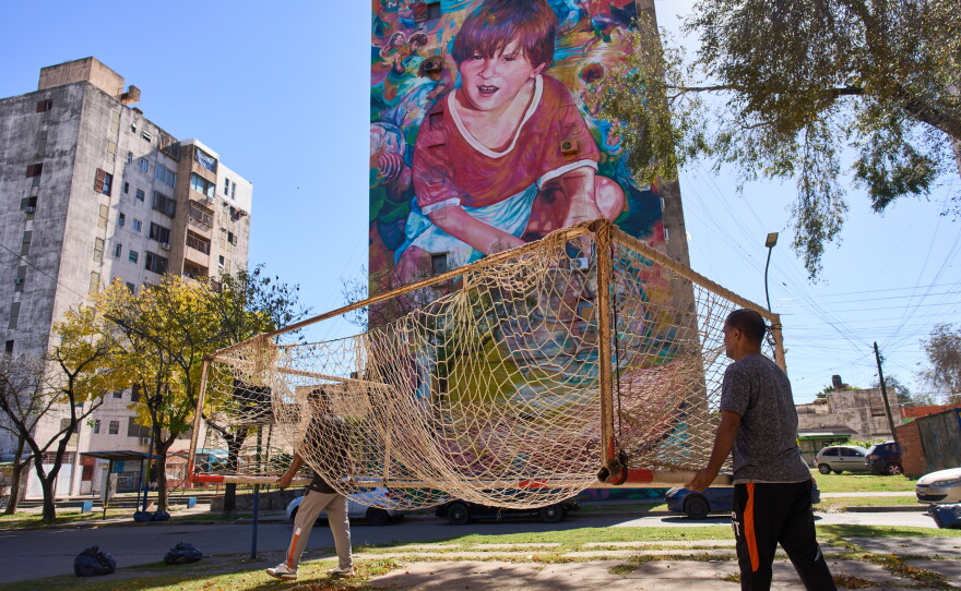 Workers from the Grandoli football club carry a goalpost to the pitch for children's soccer matches in Rosario, Argentina, in 2026.