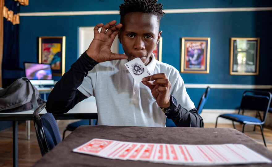 In this photo from 2021, Duma Mgqoki tries his hand at a card trick at the Cape Town College of Magic. In 2026, Mgqoki was killed in a shooting in the Philippi neighborhood of Cape Town. Many of the College's students come from neighborhoods marked by unemployment and violent crime.