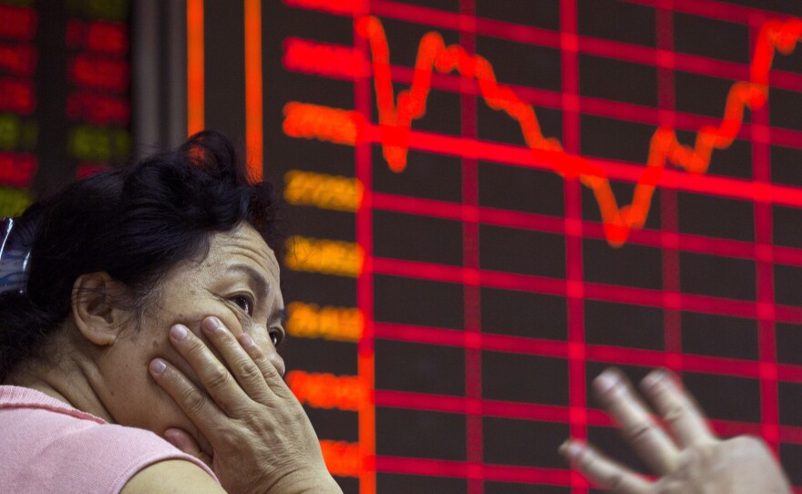 A Chinese investor monitors stock prices at a brokerage in Beijing on Wednesday. The country's stock markets have nosedived.