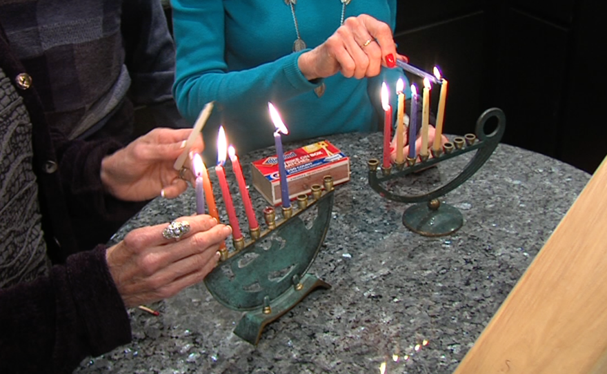 The candles are lit on two menorahs, Dec. 10, 2015.