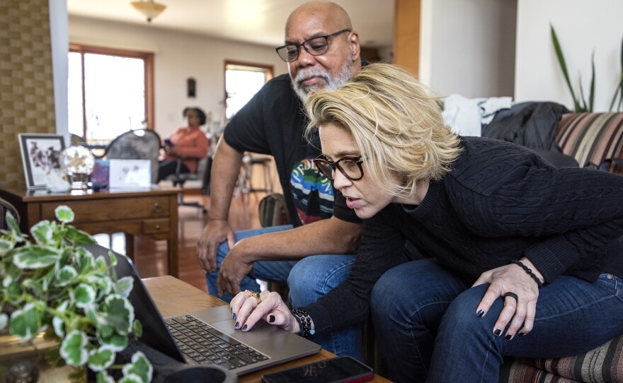 Peter Baker, left, and Katie Green, right, look at photos of Lake Ivanhoe at Peter's home in the area.
