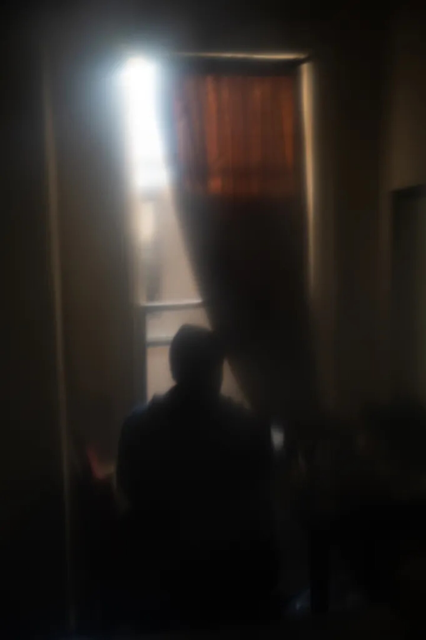 J.M., who prefers to use his initials for privacy, looks through his bedroom window at a transitional home provided through CARE Court in Oakland on Dec. 1, 2025.