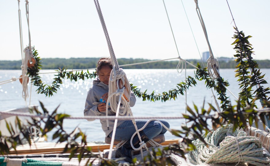 Kala Tanaka marks "stays" at the front of the canoe so they can go back in the same place after the mast is taken down to fit under the George Washington Bridge. The garlands of ti leaves, a Hawaiian tradition, were placed on the Hokule'a by well-wishers.