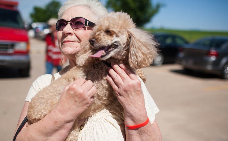 Marylin Degman holds her 10-year-old toy poodle, Angel Baby, on Wednesday outside the First Baptist Church in Moore, Okla.