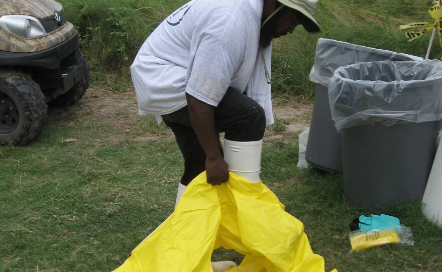 Jerome Benjamin of New Orleans slips into a hazardous material suit. He's among the temporary workers hired to clean up the beaches.