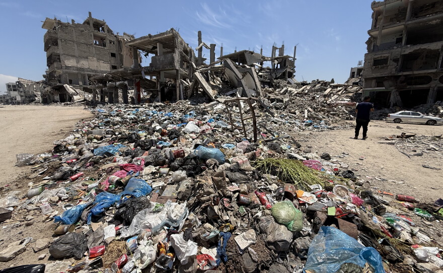 Piles of uncollected garbage and debris line a deserted street in al-Shuja'iyya, a neighborhood, lacking basic services and aid due to israel restrictions as expanding the orange zone.