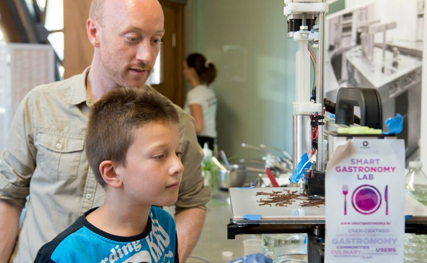 Lab visitors watch a 3-D printer squirt chocolate into an intricate shape designed by chef Arabelle Meirlaen.