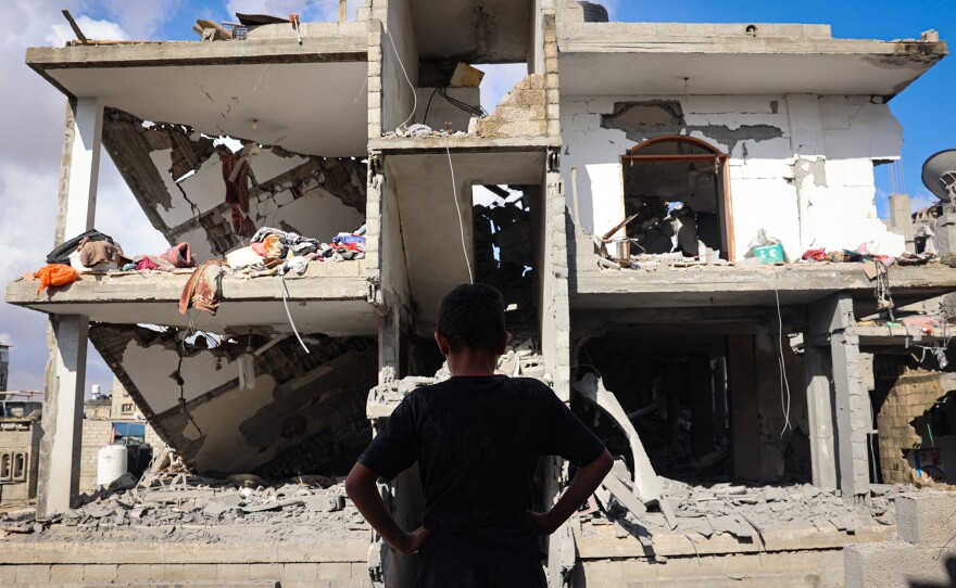 A Palestinian youth stands in front of a destroyed building following Israeli bombardment of Rafah's Tal al-Sultan district in the southern Gaza Strip on Tuesday. The Israeli army said it took "operational control" of the Palestinian side of the Rafah border crossing between Gaza and Egypt and that troops were scanning the area.