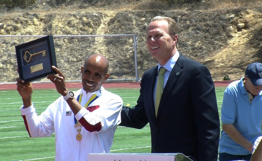 Boston Marathon winner Meb Keflezighi receives a key to the city of San Diego from Mayor Kevin Faulconer on Saturday, May 10, 2014.