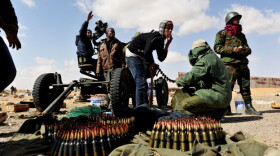 Rebel fighters loaded ammunition into an anti-aircraft machine gun Tuesday as Libyan air force fighter jets flew overhead in the oil-rich town of Ras Lanuf.