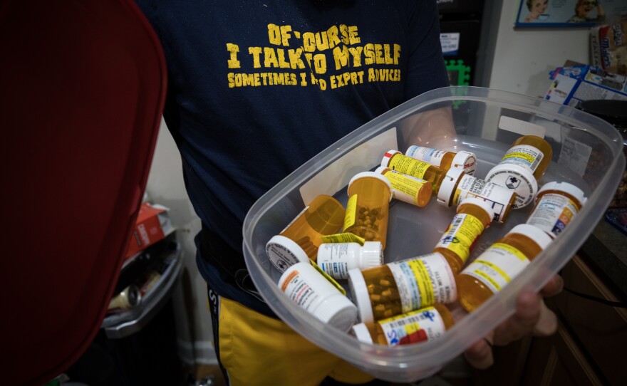 Marquette looks through some of the myriad medications he takes.