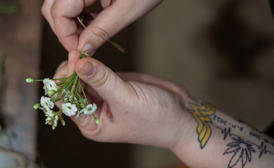 Bridget Barton works on a corsage for a family member's wedding at home in Osawatomie, Kan. Barton now uses arts and crafts projects as a therapeutic way to deal with the trauma she experienced during the shootings at the Super Bowl parade in Kansas City, Mo.