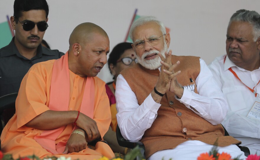 Indian Prime Minister Narendra Modi speaks with of Yogi Adityanath (left), a Hindu priest who is chief minister of Uttar Pradesh, during a campaign rally on March 28.