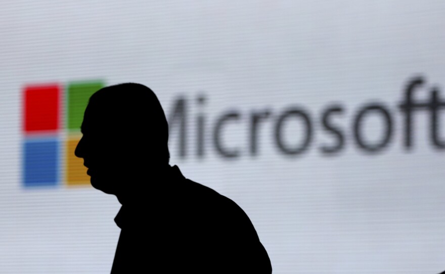 An unidentified man walks in front of the Microsoft logo at an event in New Delhi, India. Microsoft is at the center of a Supreme Court case on whether it has to turn over emails stored overseas.