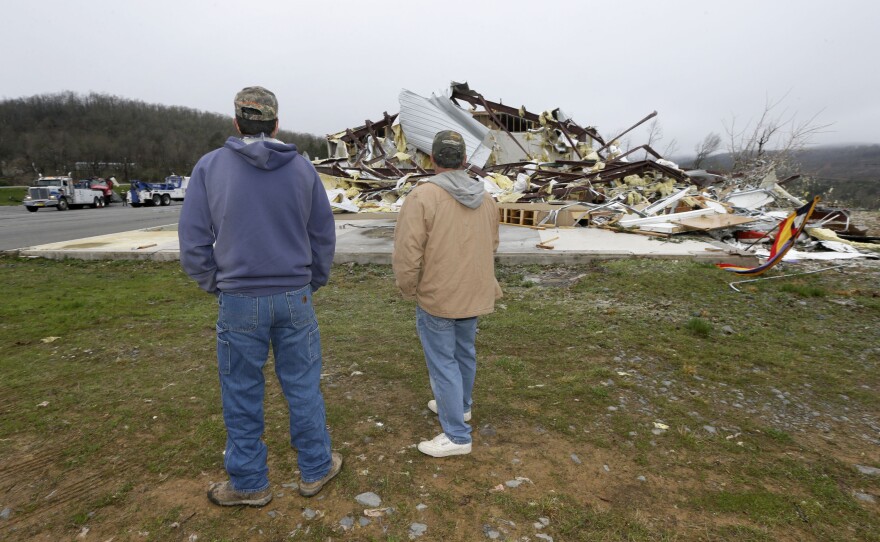 Larry Gammill, left, and Tim Parks survey tornado damage at a church in Botkinburg, Ark. on Thursday after the building was hit by a tornado. Three tornadoes touched down in Arkansas on Wednesday. The National Weather Service is warning more storms are on the horizon as another warm, wet front is moving up from the Gulf of Mexico.